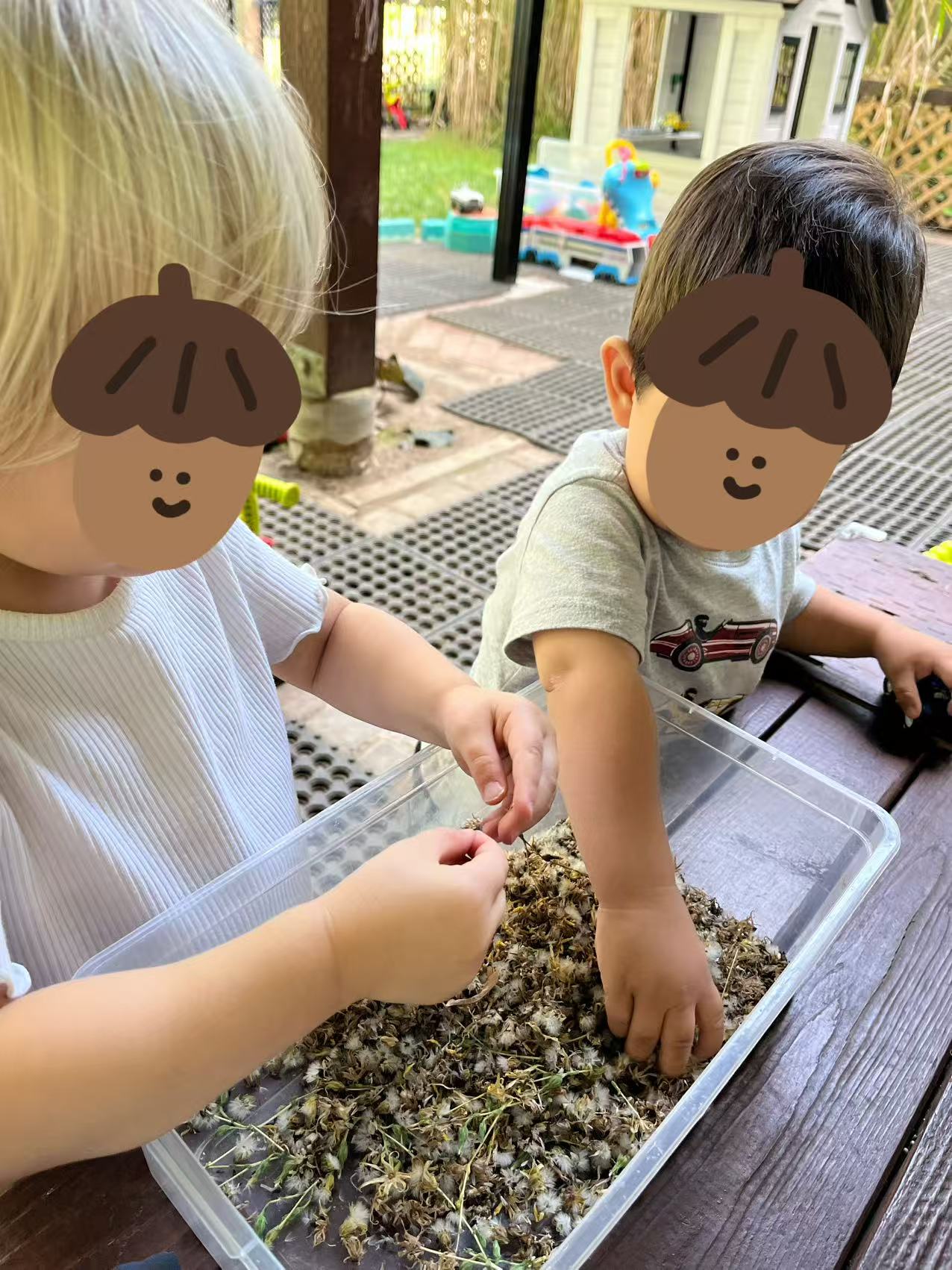 Children exploring a nature sensory bin outdoors at Forest Cubs Childcare